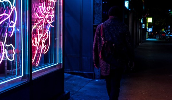 photo of person outside a dimly lit bar at night