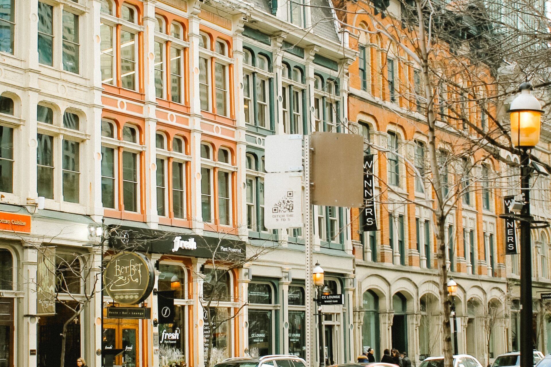 Cars on a road in front of buildings of different colours