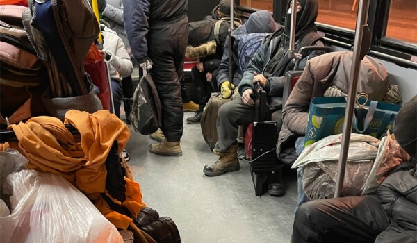 People rest inside a TTC bus late at night