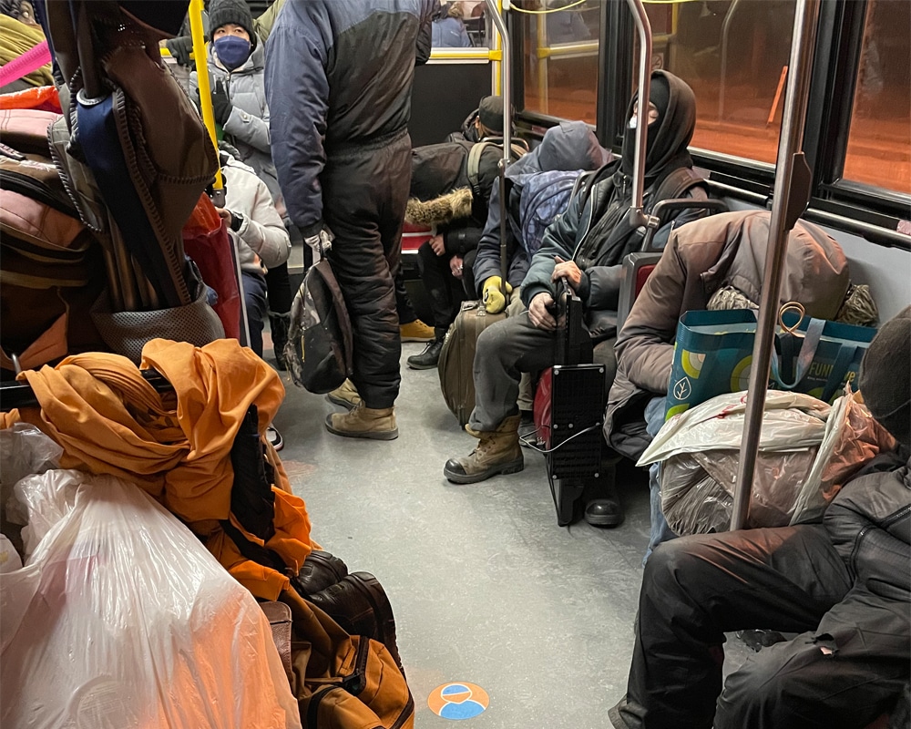 People rest inside a TTC bus late at night